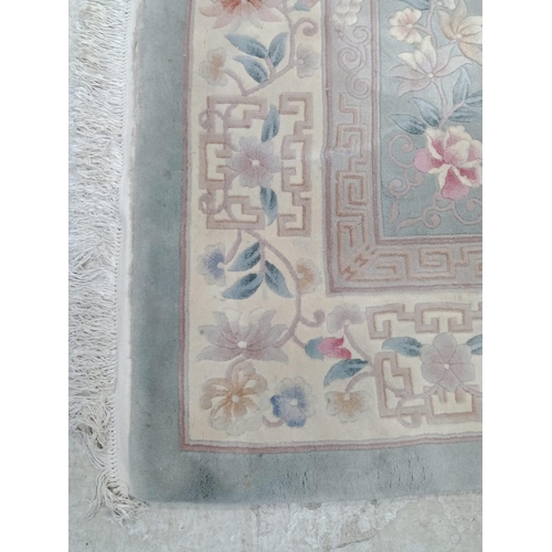 493 - A CHINESE WASHED AND FRINGED CARPET, the pale green field with central circular floral gul in rose p... 