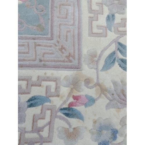 493 - A CHINESE WASHED AND FRINGED CARPET, the pale green field with central circular floral gul in rose p... 