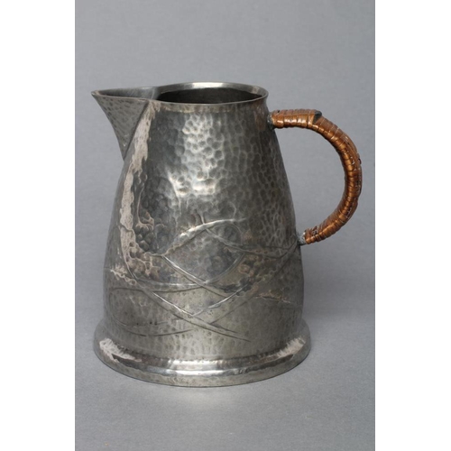 503 - ARCHIBALD KNOX FOR LIBERTY - a Tudric pewter jug of tapering rounded cylindrical form, repousse with... 