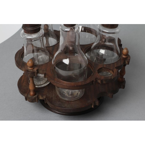 509 - A GEORGIAN HARDWOOD FIVE BOTTLE CRUET AND STAND, late 18th century, the original clear glass baluste... 