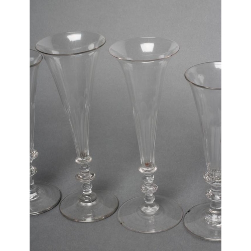 57 - A COLLECTION OF EIGHT CHAMPAGNE FLUTES, early 19th century and later, six with panelled bowls, on kn... 