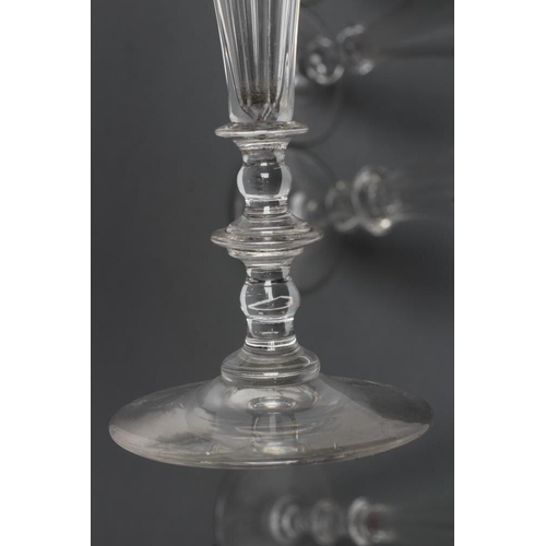 57 - A COLLECTION OF EIGHT CHAMPAGNE FLUTES, early 19th century and later, six with panelled bowls, on kn... 