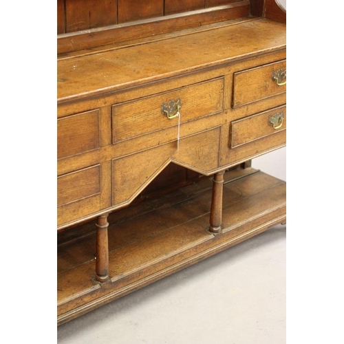 775 - AN OAK DRESSER, early 19th century, the boarded delft rack with moulded cornice and frieze with iron... 