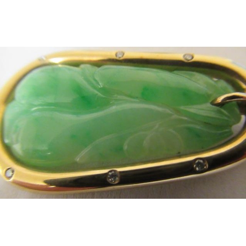 381 - A JADE PENDANT, the tear shaped panel carved with stylised fruit pierced to hang from a cylindrical ... 