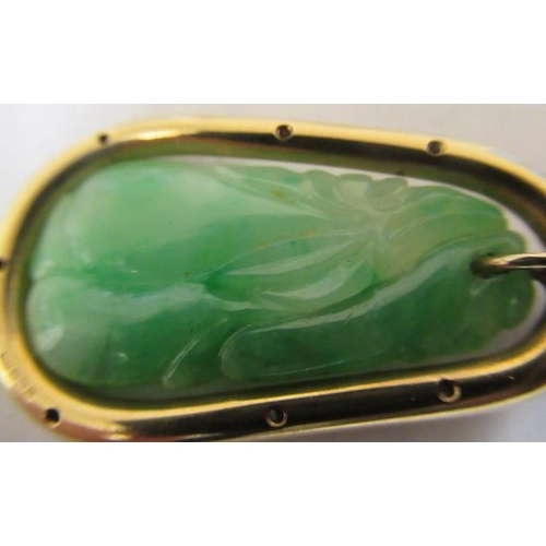 381 - A JADE PENDANT, the tear shaped panel carved with stylised fruit pierced to hang from a cylindrical ... 