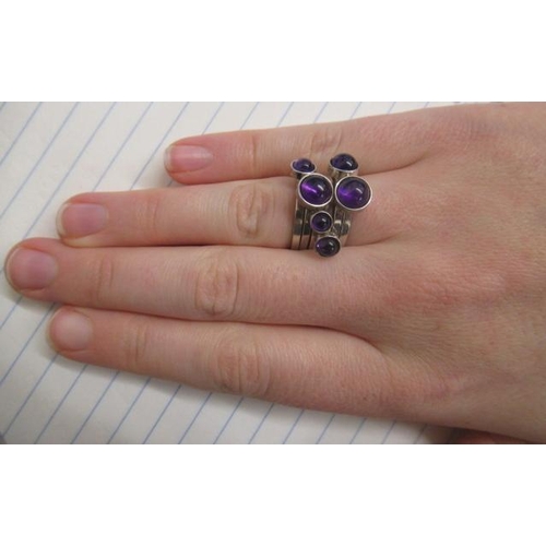 402 - A WENDY RAMSHAW SILVER AND AMETHYST STACKING RING, the six plain rings each set with a graduated clo... 