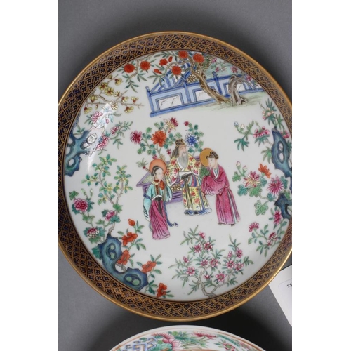 16 - A CHINESE PORCELAIN FAMILLE ROSE SAUCER painted with three figures in a garden within a blue and gil... 