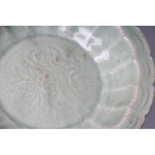 23 - A CHINESE CELADON GLAZED SMALL DISH of lobed circular form, centrally carved with a flower spray, 5 ... 