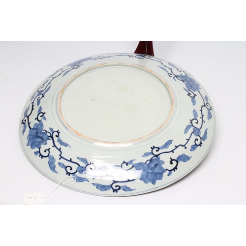 24 - A JAPANESE PORCELAIN CHARGER of plain circular form, centrally painted in underglaze blue with a dra... 