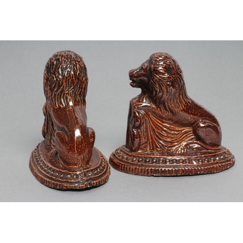 33 - A PAIR OF BRAMPTON TYPE BROWN SALTGLAZE STONEWARE LIONS, early 19th century, modelled resting their ... 