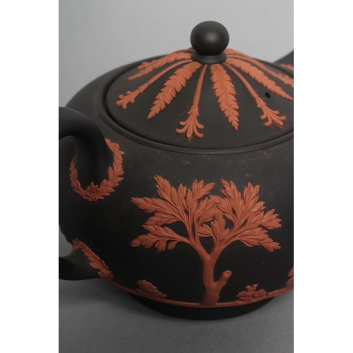 49 - A WEDGWOOD ROSSO ANTICO TEAPOT AND COVER, 1988, of squat globular form, with classical figure sprigg... 