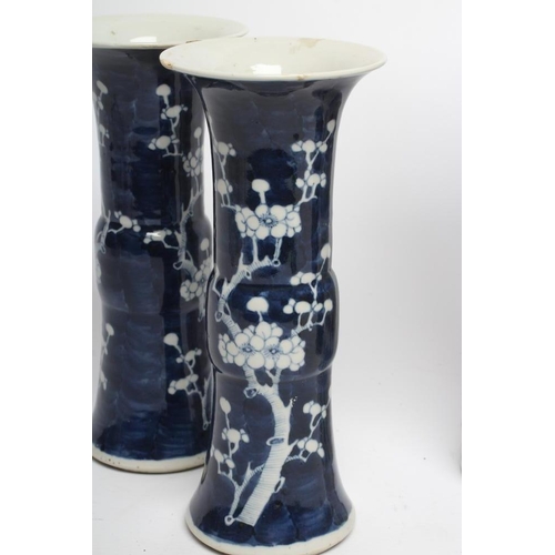 6 - A PAIR OF CHINESE PORCELAIN GU VASES painted in underglaze blue with prunus on a dark shaded ground,... 