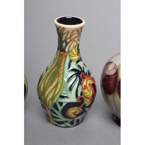 82 - THREE MOORCROFT POTTERY SMALL VASES, comprising a globular example with art nouveau style flowerhead... 