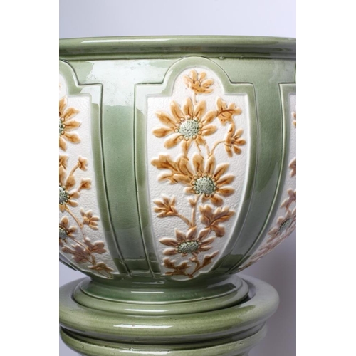 96 - A BURMANTOFTS FAIENCE JARDINIERE AND STAND, early 20th century, moulded with panels of flowers paint... 