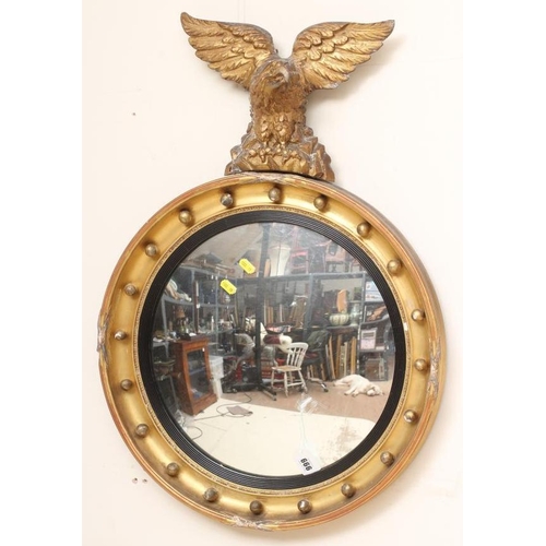 666 - A GILT WOOD CONVEX WALL MIRROR, 19th century, the cavetto moulded frame with eagle surmount and appl... 