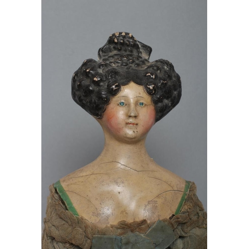 105 - A papier mache doll, c.1830, shoulder head with moulded hair and painted features, shaped and painte... 