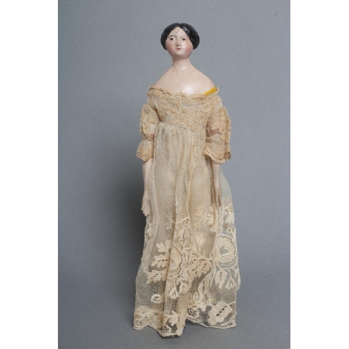 106 - A papier mache doll, c.1840, shoulder head with moulded hair and painted features, shaped and painte... 