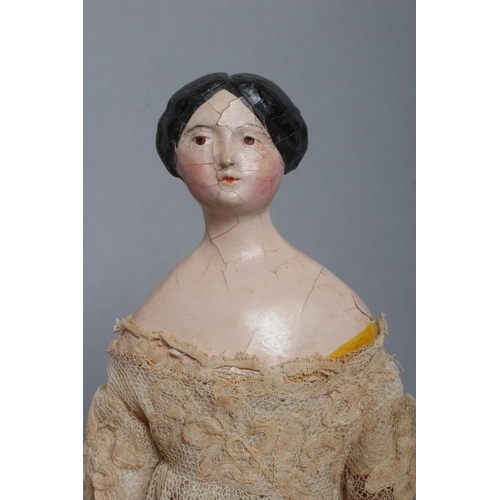 106 - A papier mache doll, c.1840, shoulder head with moulded hair and painted features, shaped and painte... 