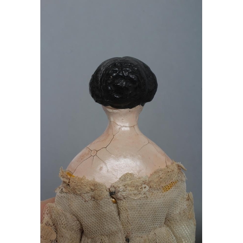 106 - A papier mache doll, c.1840, shoulder head with moulded hair and painted features, shaped and painte... 