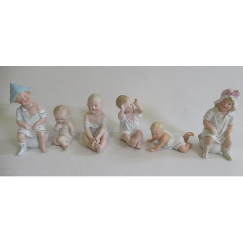 136 - Six bisque Gebruder Heubach piano babies, five seated and one crawling, largest 5 1/2