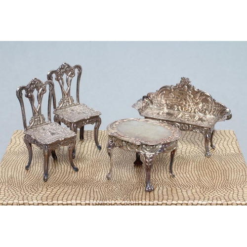 160 - A boxed set of sterling silver doll's house furniture, comprising a pair of chairs, bench and table,... 