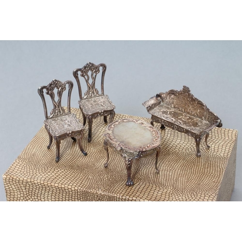 160 - A boxed set of sterling silver doll's house furniture, comprising a pair of chairs, bench and table,... 