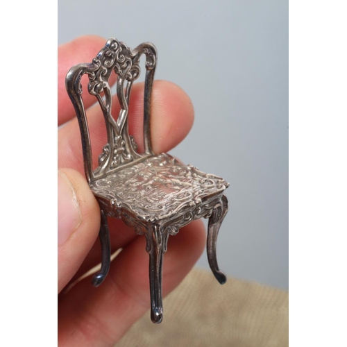 160 - A boxed set of sterling silver doll's house furniture, comprising a pair of chairs, bench and table,... 