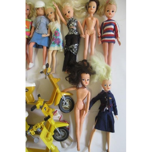 197 - Eleven Sindy dolls, of mixed ages, together with a small quantity of clothing and three mopeds (Est.... 