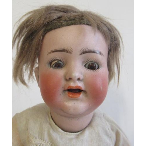 20 - A Kammer & Reinhardt bisque socket head doll, with brown glass eyes, open mouth, teeth, brown wig, w... 