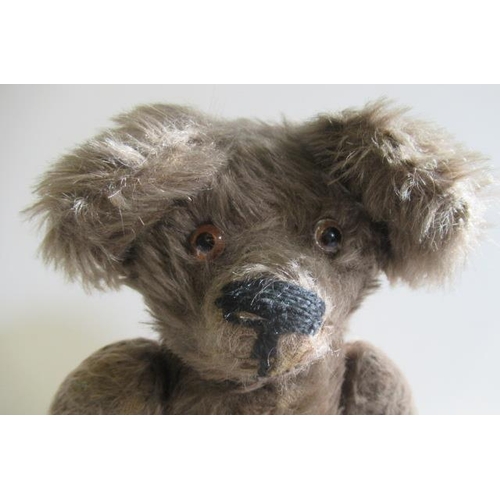 213 - An old teddy bear, with light brown plush, glass eyes, sewn nose, large ears, hump and fabric pads, ... 