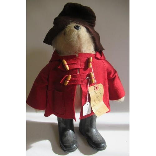 215 - A Paddington Bear, with amber eyes, brown felt hat, red felt coat, black wellies and original label,... 