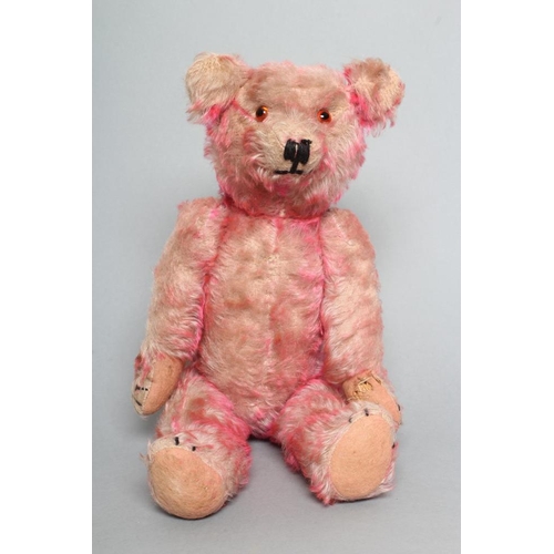 218 - A pre-war pink musical jointed teddy bear, with wind-up mechanism, pink plush, amber eyes, sewn nose... 