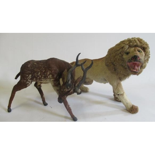 226 - Two real hair plush animals, comprising a deer and a lion, both wrapped in hide and modelled standin... 