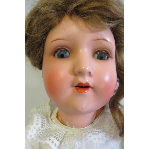 76 - A German bisque socket head doll, with blue glass sleeping eyes, open mouth, teeth, auburn wig, wood... 