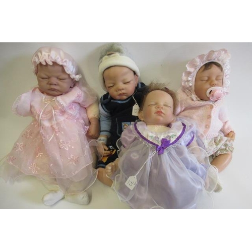 77 - Four Ashton Drake dolls, with vinyl/silicone heads and soft bodies, all with closed eyes, largest 21... 