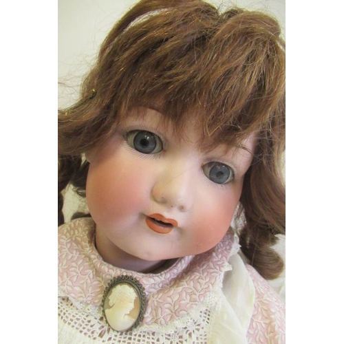 87 - An Armand Marseille bisque socket head doll, with blue glass sleeping eyes, open mouth, teeth, brown... 