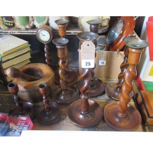 25 - COLLECTION OF WOODEN CANDLESTICKS WITH A CLOCK AND PESTLE AND MORTAR