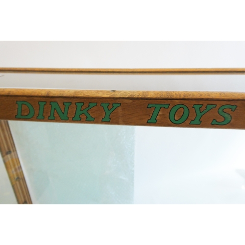 612 - A glass toy shop display cabinet, wooden frame, with four glass shelves, DINKY TOYS to front, 30