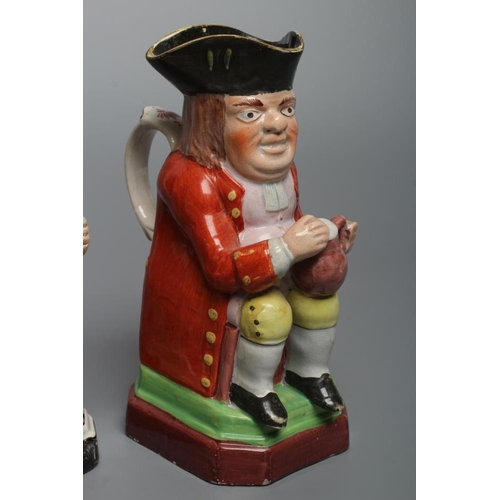 24 - A PEARLWARE SMALL TOBY JUG, c.1800, wearing a tricorn hat, red coat, pink waistcoat and yellow breec... 