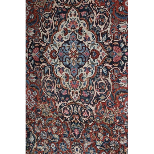 282 - A PERSIAN RUG, the red floral field with navy blue and ivory gul, the navy blue main border with scr... 