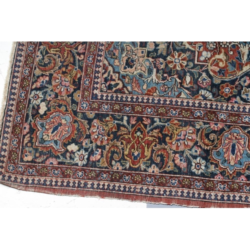 282 - A PERSIAN RUG, the red floral field with navy blue and ivory gul, the navy blue main border with scr... 