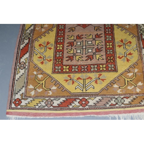 291 - A KAZAK TYPE RUG, the oblong field with central rust coloured gul and similar border, on a bold yell... 