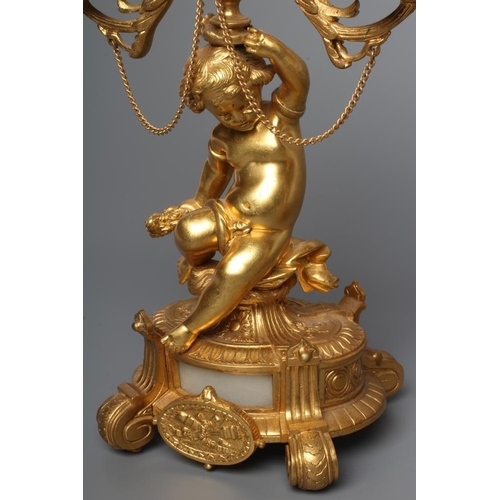 293 - A PAIR OF FRENCH GILT METAL THREE LIGHT FIGURAL CANDELABRA inset with onyx panels, early 20th centur... 