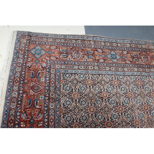 298 - A PERSIAN RUG, the ivory field with all over repeating flowerhead and leaf pattern in shades of blue... 