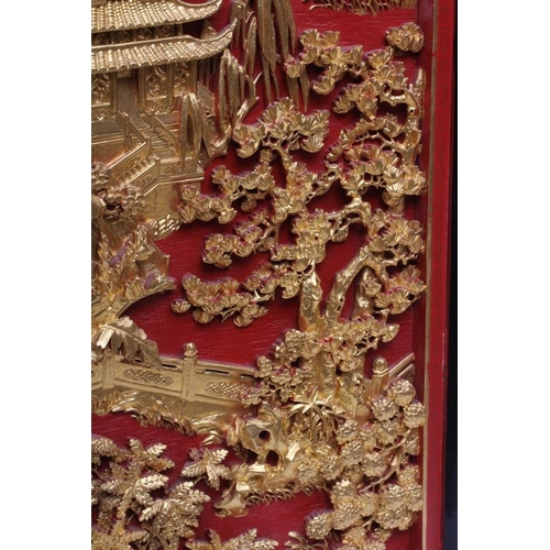 312 - A PAIR OF CHINESE CARVED WOOD WALL PANELS, 20th century, gilded with garden scenes in high relief on... 