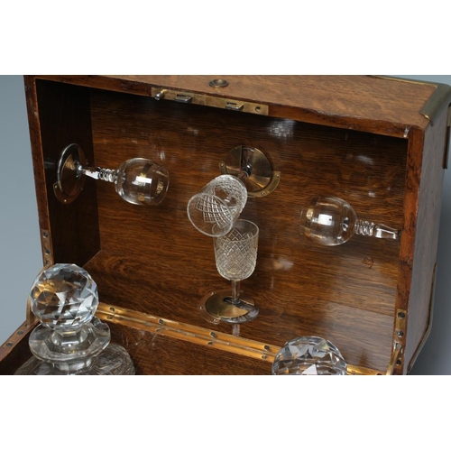 314 - A VICTORIAN OAK AND BRASS BOUND TRAVELLING DRINKS CABINET, the hinged lid and split hinged fascia op... 