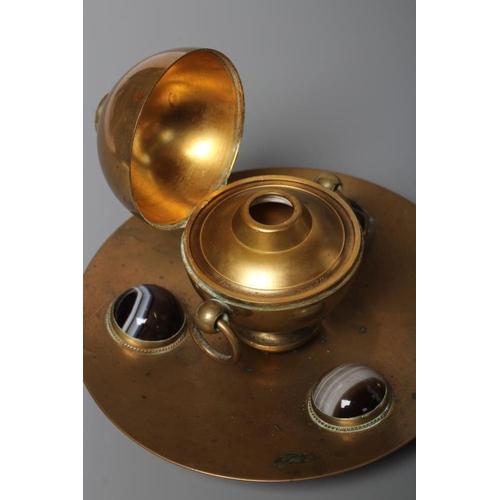 325 - A VICTORIAN BRASS INKWELL of dished circular form, the spherical well with two ring handles on a sli... 