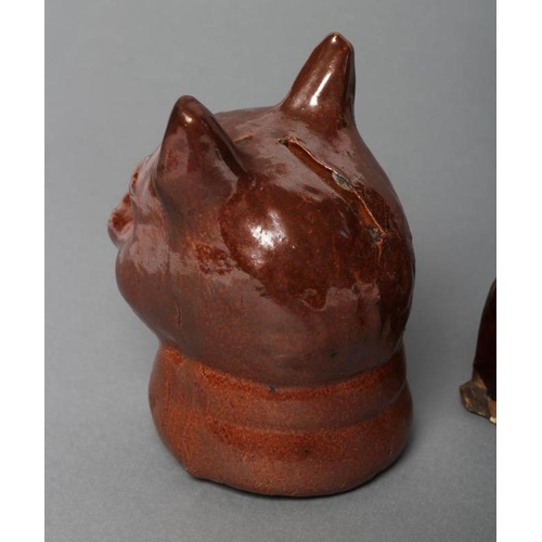 33 - AN ENGLISH TREACLE GLAZED STONEWARE CAT, early 19th century, modelled seated on an oblong base, 7 1/... 