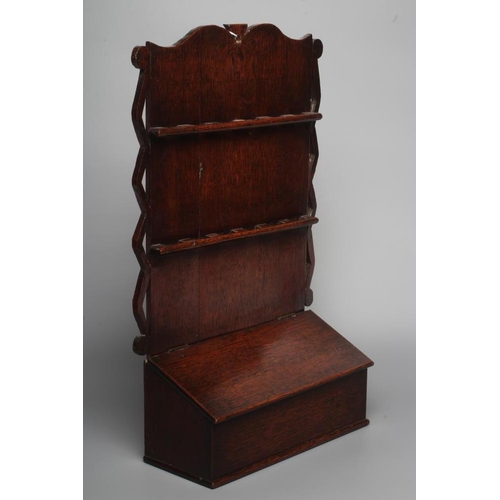 339 - A GEORGIAN OAK SPOON RACK, late 18th century, the boarded back with waved crest over two rows of con... 