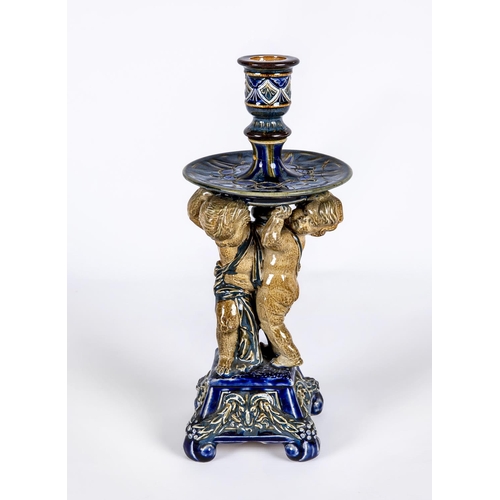 70 - A STONEWARE FIGURAL CANDLESTICK, probably designed by George Tinworth for Doulton Lambeth, the reel ... 